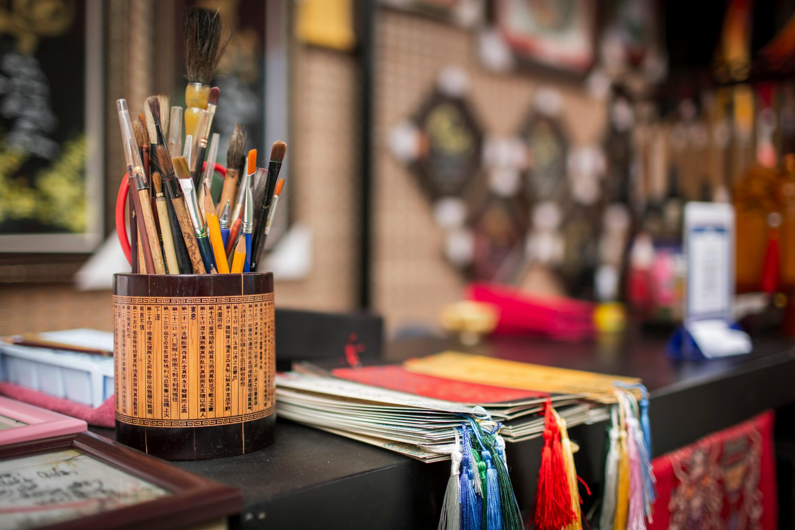 pexels-photo-30245877-30245877 Traditional Vietnamese calligraphy tools set against a colorful backdrop at a crafts stall in Ho Chi Minh City.